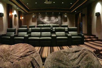 Inspiration for a mid-sized contemporary enclosed carpeted and multicolored floor home theater remodel in Salt Lake City with gray walls and a projector screen