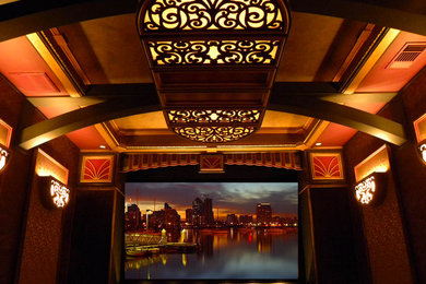 Modelo de cine en casa cerrado tradicional renovado con paredes rojas y pantalla de proyección