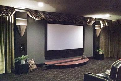Large elegant enclosed carpeted and gray floor home theater photo in Atlanta with green walls and a media wall
