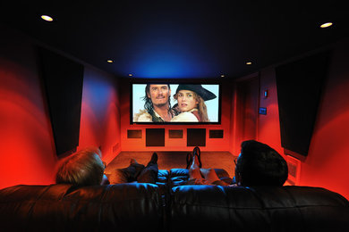 Ejemplo de cine en casa cerrado minimalista pequeño con paredes rojas, moqueta y pantalla de proyección