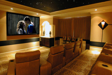 Modelo de cine en casa cerrado actual grande con paredes beige, moqueta, televisor colgado en la pared y suelo marrón
