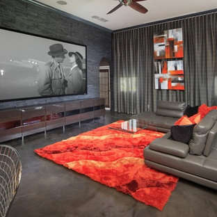 Ispirazione per un grande home theatre contemporaneo aperto con pareti grigie, schermo di proiezione, pavimento in cemento e pavimento grigio