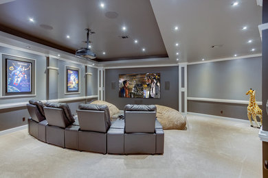 Imagen de cine en casa cerrado moderno grande con paredes grises, moqueta y pantalla de proyección