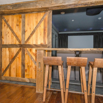 Rustic finished basement with theater room, rustic sliding barn doors