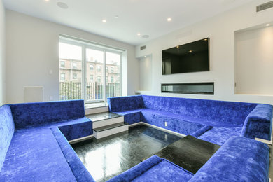 Photo of a large modern enclosed home cinema in Boston with a built-in media unit, grey walls, dark hardwood flooring and black floors.