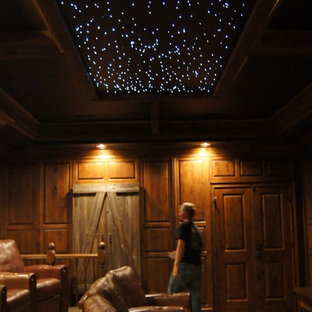 Large elegant enclosed carpeted home theater photo in Other with a projector screen