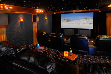 Foto de cine en casa cerrado ecléctico de tamaño medio con paredes negras, moqueta, televisor colgado en la pared y suelo negro