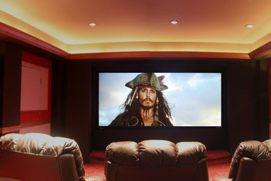 Foto de cine en casa cerrado moderno grande con paredes rojas, moqueta, pantalla de proyección y suelo rojo
