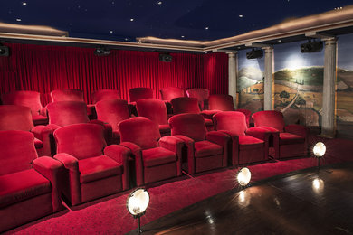 Imagen de cine en casa cerrado ecléctico grande con paredes rojas, moqueta y pantalla de proyección