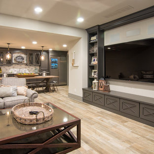 Ispirazione per un ampio home theatre shabby-chic style aperto con pareti bianche, pavimento in laminato, pavimento beige e TV a parete