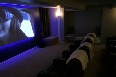 Small minimalist enclosed carpeted home theater photo in Kansas City with a projector screen