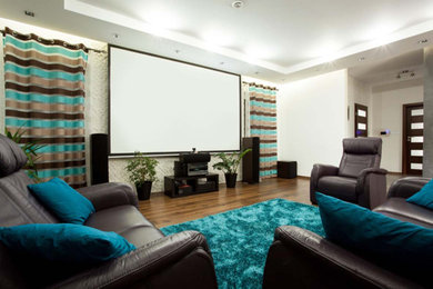 Foto de cine en casa cerrado actual grande con paredes blancas, suelo de madera en tonos medios, pantalla de proyección y suelo marrón
