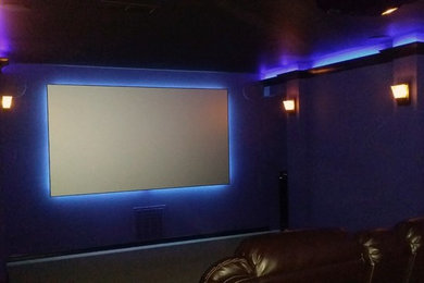 Imagen de cine en casa cerrado contemporáneo de tamaño medio con paredes púrpuras, moqueta y pantalla de proyección