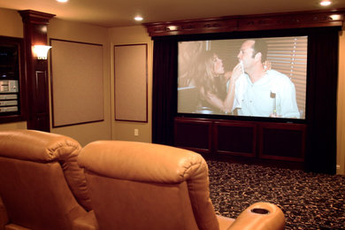 Modelo de cine en casa cerrado clásico de tamaño medio con paredes beige, moqueta, pantalla de proyección y suelo marrón
