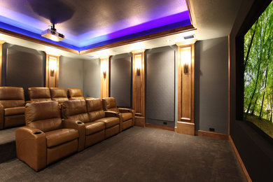 Ejemplo de cine en casa cerrado tradicional grande con paredes grises, moqueta y pantalla de proyección