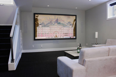 Example of a mid-sized trendy enclosed carpeted home theater design in Calgary with gray walls and a projector screen