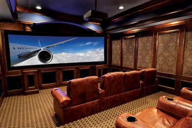 Imagen de cine en casa cerrado clásico grande con paredes marrones, moqueta, pantalla de proyección y suelo multicolor