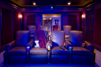 Пример оригинального дизайна: большой изолированный домашний кинотеатр в классическом стиле с проектором, красными стенами, ковровым покрытием и бежевым полом