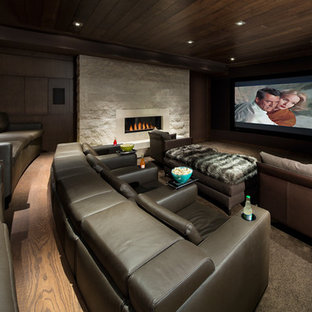 Diseño de cine en casa cerrado, contemporáneo, extra grande, con paredes marrones, moqueta, pantalla de proyección y suelo marrón