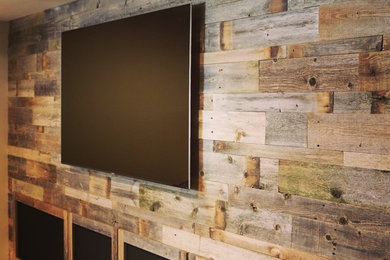 Foto de cine en casa cerrado minimalista de tamaño medio con paredes beige y televisor colgado en la pared
