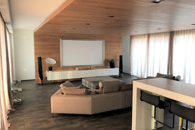 Ejemplo de cine en casa contemporáneo con paredes blancas, pared multimedia y suelo marrón