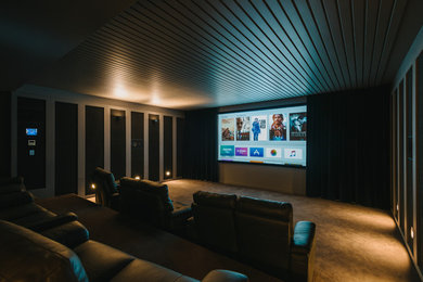 Aménagement d'une salle de cinéma contemporaine de taille moyenne et fermée avec moquette et un écran de projection.