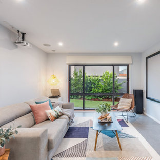 This is an example of a mid-sized contemporary open concept home theatre in Canberra - Queanbeyan with a projector screen.