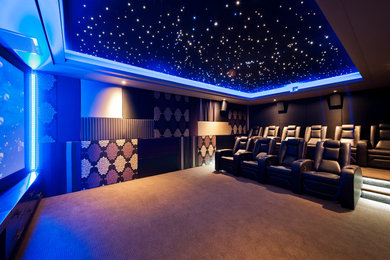 Modelo de cine en casa cerrado contemporáneo extra grande con paredes multicolor y pantalla de proyección
