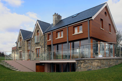 Modelo de fachada contemporánea grande de tres plantas con revestimiento de madera y tejado a dos aguas