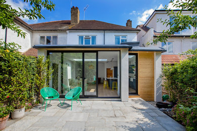 Inspiration for a medium sized and white contemporary bungalow render house exterior in London with a flat roof.