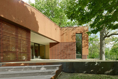 Ejemplo de fachada marrón moderna de tamaño medio de una planta con revestimientos combinados