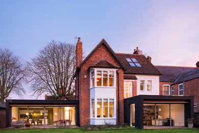 Inspiration for a large classic two floor brick house exterior in Other with a pitched roof.
