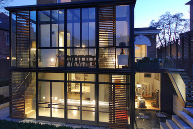Immagine della facciata di una casa grande contemporanea a tre piani con rivestimenti misti e tetto piano
