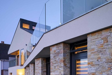 Стильный дизайн: большой, двухэтажный, разноцветный частный загородный дом в стиле модернизм с облицовкой из цементной штукатурки, двускатной крышей и металлической крышей - последний тренд