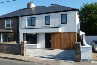 Inspiration for a medium sized and white contemporary two floor render semi-detached house in Cork with a pitched roof and a tiled roof.