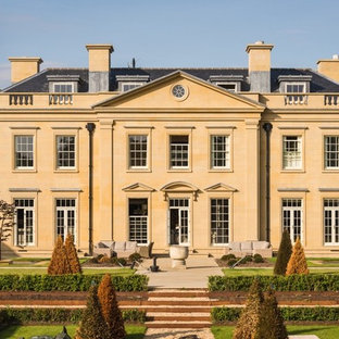 Photo of an expansive and beige classic detached house in Surrey with three floors.