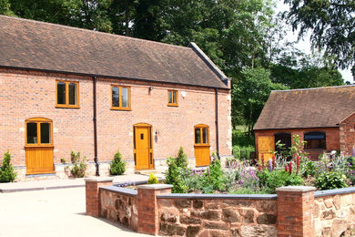 Photo of a medium sized and red rural two floor brick house exterior in West Midlands with a pitched roof.