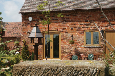 Inspiration for a red rustic brick house exterior in West Midlands.