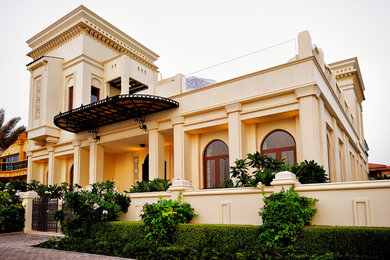 Foto della villa beige classica a tre piani di medie dimensioni con rivestimento in stucco, tetto piano e copertura verde