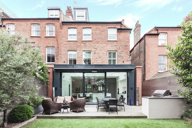 Photo of a red contemporary brick semi-detached house in London with three floors.