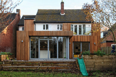 Inspiration for a medium sized and brown traditional two floor rear house exterior in West Midlands with wood cladding, a mixed material roof and a pitched roof.