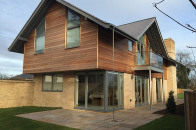 Inspiration for a large contemporary two floor house exterior in Hertfordshire with wood cladding.