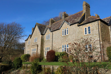 This is an example of an expansive and beige nautical two floor detached house in Devon with stone cladding, a pitched roof and a shingle roof.