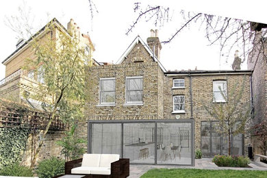Inspiration for a large and brown contemporary brick detached house in London with three floors, a flat roof and a mixed material roof.