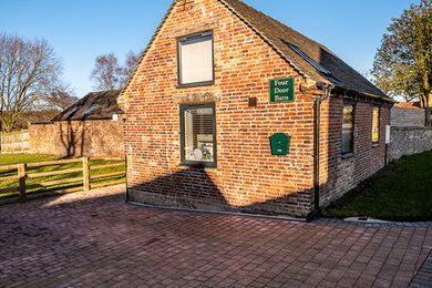 Small and red classic bungalow brick detached house in Other with a pitched roof and a tiled roof.