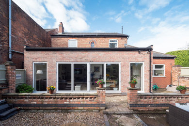 Medium sized rustic two floor brick detached house in West Midlands with a flat roof.
