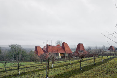 Immagine della facciata di una casa ampia marrone moderna a tre piani con rivestimento in adobe e tetto a capanna