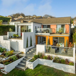 Photo of a multi-coloured and large contemporary two floor detached house in Sussex with a pitched roof, a shingle roof and mixed cladding.