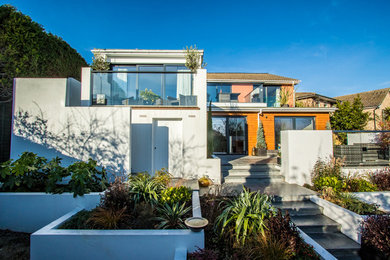 Foto de fachada de casa multicolor mediterránea grande de dos plantas con tejado a dos aguas, tejado de teja de madera y revestimientos combinados