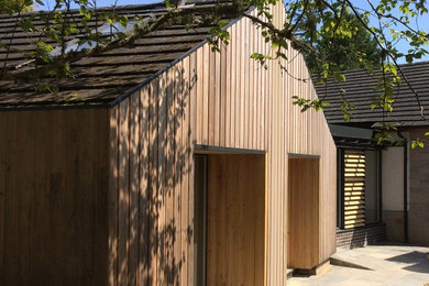 Ispirazione per la villa contemporanea a un piano di medie dimensioni con rivestimento in legno, tetto a capanna e copertura in tegole